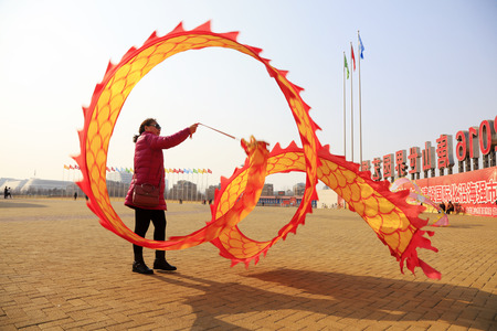 Tangshan City - February 20, 2018: people are dancing in colored silk for exercise in parks, Tangshan City, Hebei, China.のeditorial素材