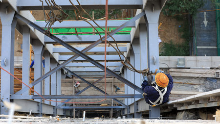 Workers install steel structures at construction sites