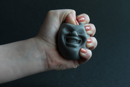 soft toy antistress in kaomaro hand on a black background