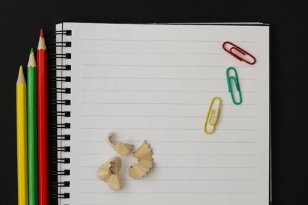 School supplies colorful pencils, notebook, paper clips on black backgroundの写真素材