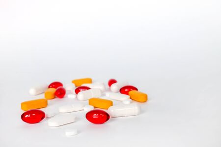 A pile of various pills, tablets and capsules isolated on a white background. Pharmacy theme, medical concept. Picture for designの写真素材