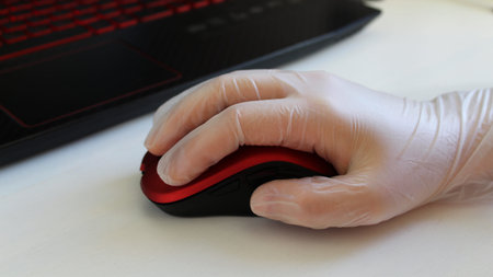 Woman is holding red stylish mouse by her hand, close up. Doctor or nurse or office worker using...