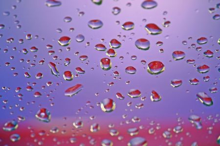 We see an unusual background. These are multi-colored drops of water on a surface.の写真素材