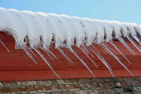 Icicle on a background of a brick wall.