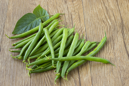 Green beans on a brown wooden tableの写真素材