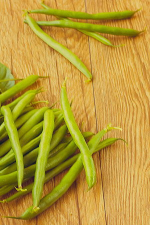 Green beans on a brown wooden table