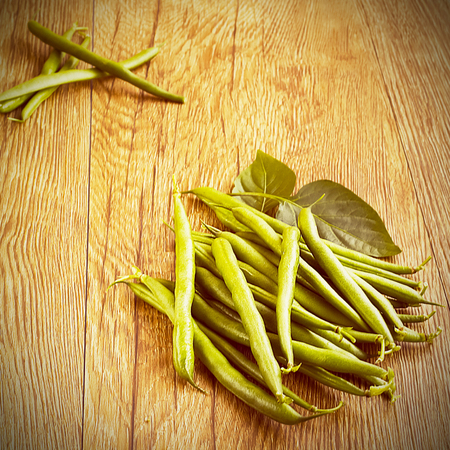 Green beans on a brown wooden tableの写真素材
