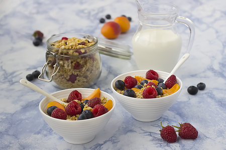 Bowls of  granola  with  fresh fruit on marble table. Soft focus.の写真素材