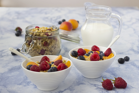 Bowls of  granola  with blueberries and fresh fruit on marble table. Soft focus.の写真素材