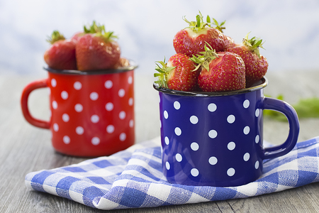 Bright ripe strawberry in a metal cups on a light background. Horizontal. Soft focus.の写真素材