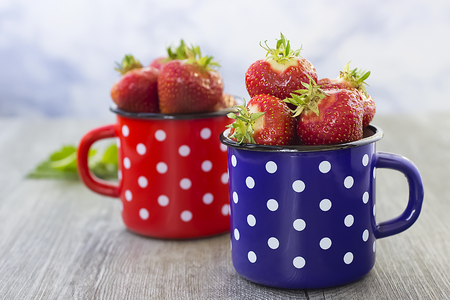 Bright ripe strawberry in a metal cups on a light background. Horizontal. Soft focus.の写真素材