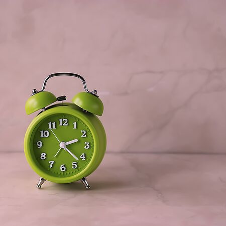 Bright green alarm clock on a light background. Soft focus.の写真素材