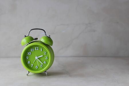 Bright green alarm clock on a light background. Soft focus.の写真素材