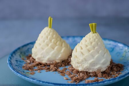 Two almond mousse cakes rotate on a blue plate. Soft focus.の写真素材