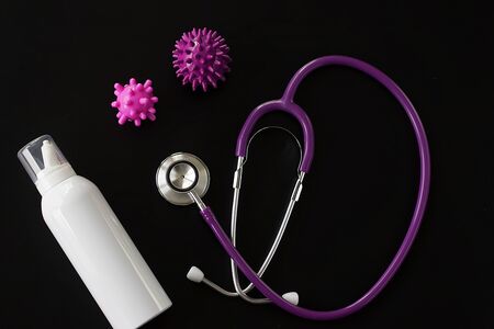 Coronavirus concept. Nasal seawater spray, stethoscope and viruses on a black background. Top view.の写真素材