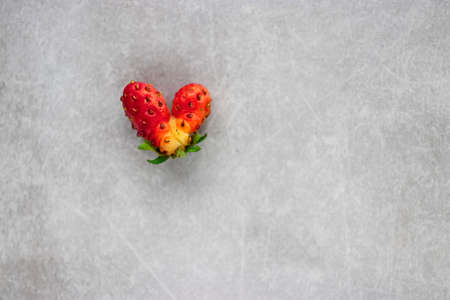 Heart shaped strawberries on a gray background. Copy space. Soft focus.の写真素材