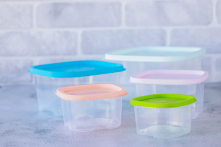 Plastic storage containers with colored lids. Soft focus.