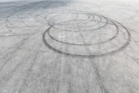 Abstract background black tire tracks skid on asphalt road, high angle shot view in racing circuitの素材 [FY31089316955]