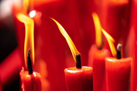 Rows of burning red candles are used in religious prayersの写真素材