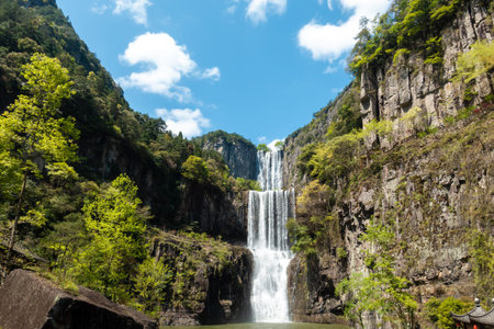 A waterfall on a cliff in the mountainsの写真素材