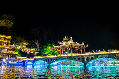 This is the night scene of Fenghuang Ancient Town in Xiangxi, Hunan, with lights reflecting on the riverの写真素材