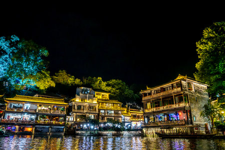 This is the night scene of Fenghuang Ancient Town in Xiangxi, Hunan, with lights reflecting on the riverの写真素材