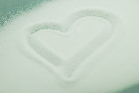 Heart made a lot of sugar on green backgroundの写真素材