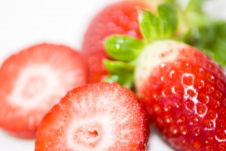 ripe red strawberries with green leaves on white backgroundの写真素材