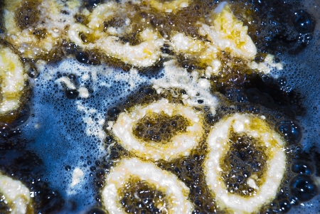squid cooking in blue boiling oil and bubblesの写真素材