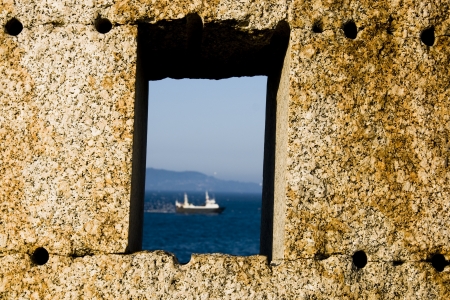 fishing boat seen through a stone windowの写真素材