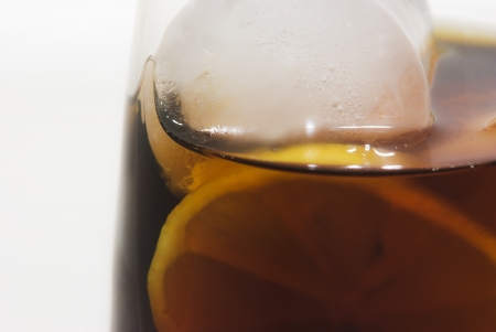 red liqueur glass with ice cubes and lemonの写真素材