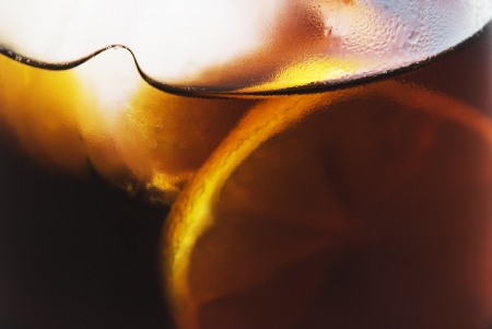 red liqueur glass with ice cubes and lemonの写真素材