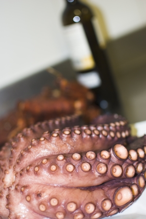 cooked octopus foreground and bottle of wine in the backgroundの写真素材