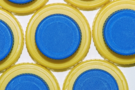 plastic caps of blue and yellow on white backgroundの写真素材