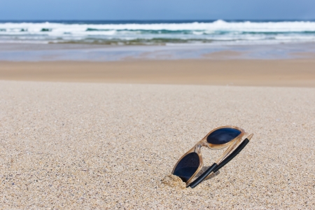 sunglasses on the sand of a lonely beachの写真素材