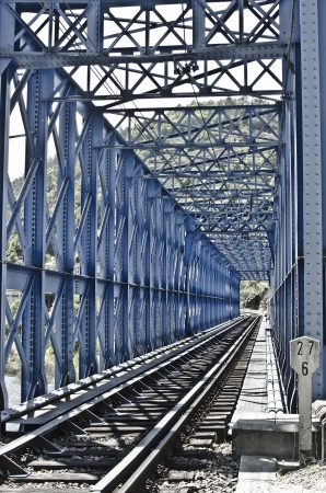 Blue metal bridge on the railroad tracksの写真素材