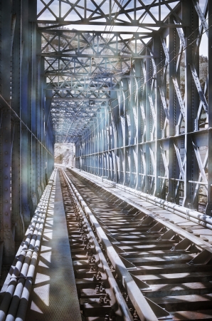 Blue metal bridge on the railroad tracksの写真素材