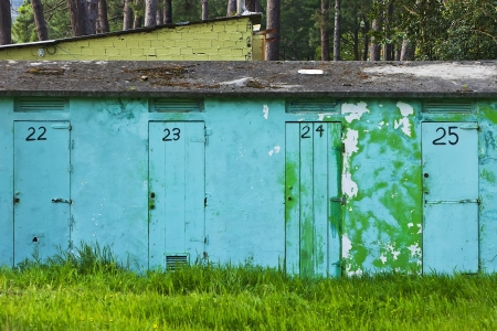 blue facade with doors numbered and forest in the backgroundの写真素材