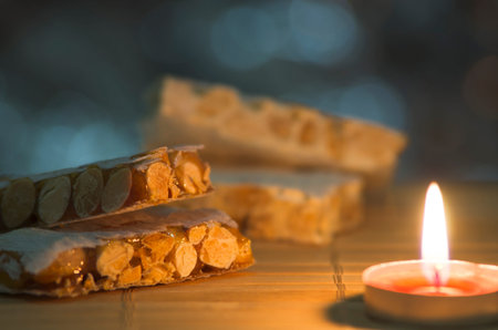 Pieces of Christmas hard almond turron on blurred background