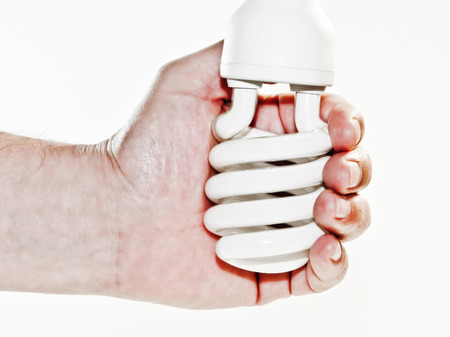 hand grasps fluorescent lamp on white backgroundの写真素材