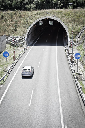 cars circulating in the entrance of the tunnel on the highwayの写真素材
