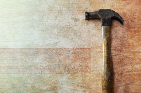 Worn hammer on wooden background.の写真素材