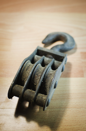 Close up old and dirty pulley on wooden background.の写真素材