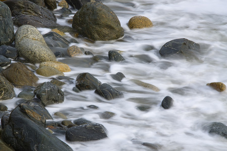 Water waves on rocks at a beachの写真素材