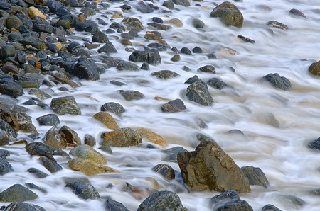 Water waves on rocks at a beachの写真素材