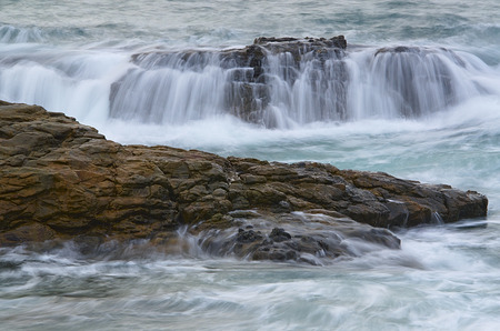 Water waves on rocks at a beachの写真素材