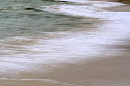 small waves breaking on the beachの写真素材