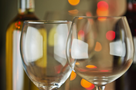 Empty wine glasses, with bottles  at the backgroundの写真素材