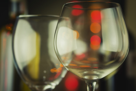 Empty wine glasses, with bottles  at the backgroundの写真素材