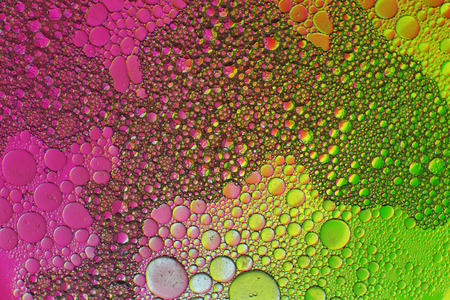 Oil drops in water on a coloured backgroundの写真素材